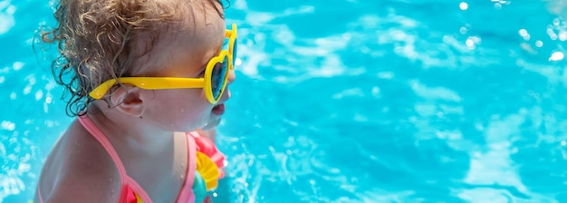 Bebé nada en la piscina Enfoque selectivo