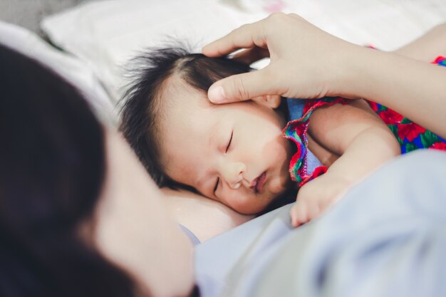 Bebé niña duerme con tía en casa