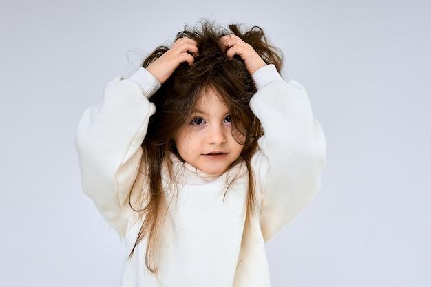 Bebé niña toca y enreda su cabello.