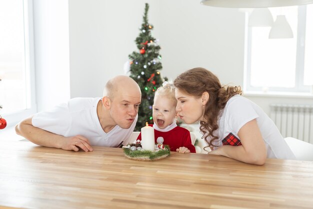 Bebé niño con audífono e implante coclear divirtiéndose con los padres en la sala de navidad div sordo