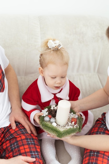 Bebé niño con audífono e implante coclear divirtiéndose con los padres en la sala de navidad div sordo