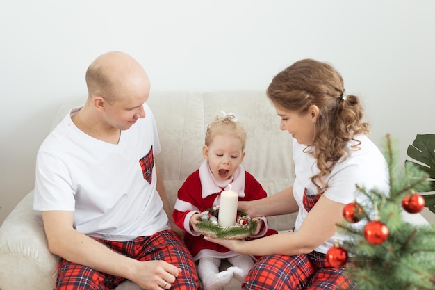 Bebé niño con audífono e implante coclear divirtiéndose con los padres en la sala de navidad Diversidad sorda y concepto de salud