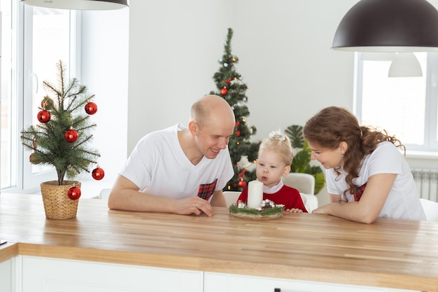 Bebé niño con audífono e implante coclear divirtiéndose con los padres en la sala de navidad Diversidad sorda y concepto de salud