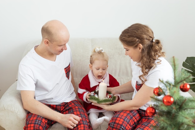 Bebé niño con audífono e implante coclear divirtiéndose con los padres en la sala de navidad Diversidad sorda y concepto de salud