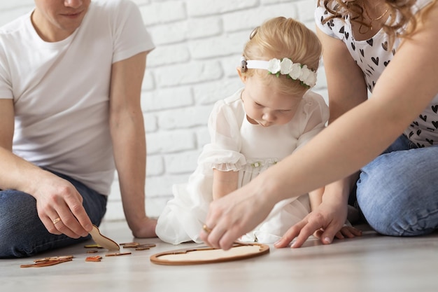 Bebé niño con audífonos e implantes cocleares juega con los padres en el piso sordo y rehabilitado