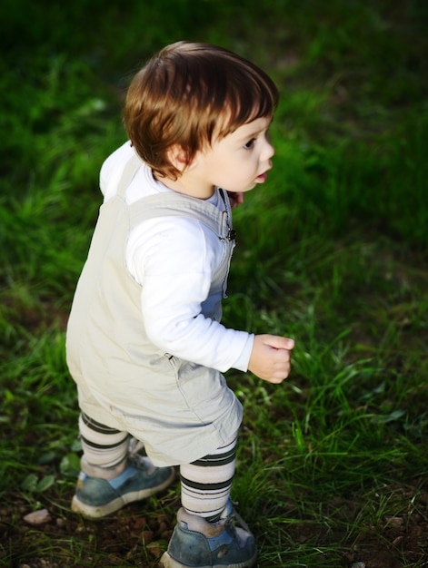 Bebé niño caminando sobre la hierba verde