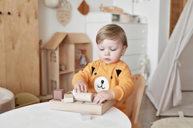 Bebé niño juega con constructor de juguetes de madera Desarrollo temprano