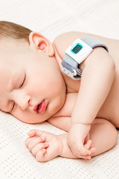 Bebê no berço mede a temperatura corporal