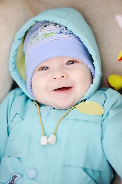 Bebê no casaco azul sorrindo para a câmera