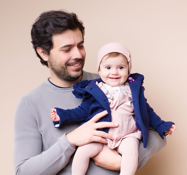 Foto bebê nos braços do papai sorrindo