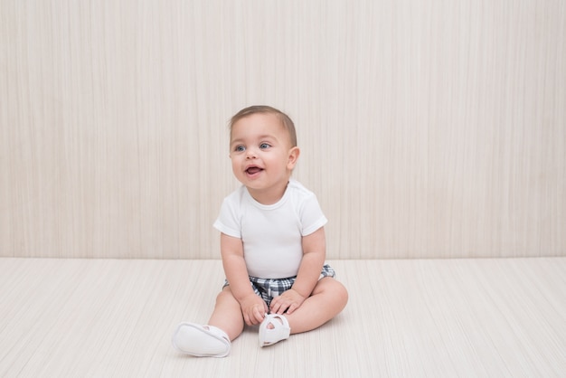 Bebé de ojos azules en el fondo de madera blanco