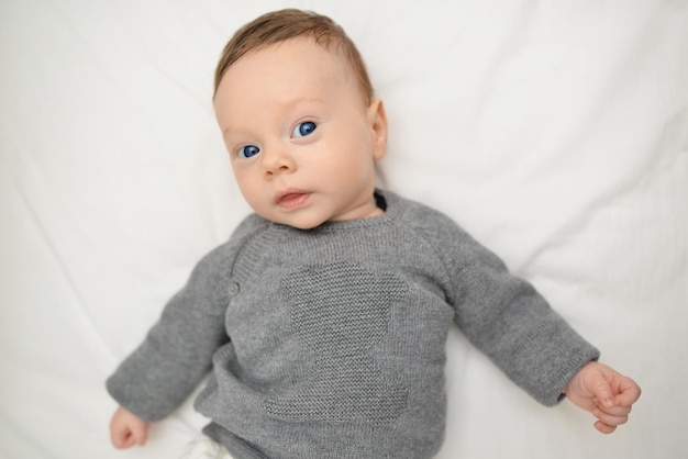 Un bebé con ojos azules mira a la cámara con curiosidad Vista superior