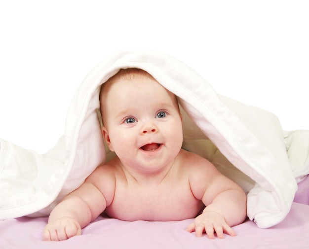 Bebê olhando debaixo do cobertor