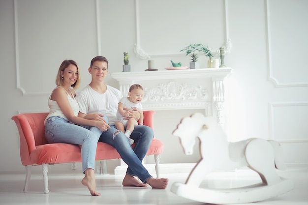 bebé con padres en una casa acogedora / familia joven y saludable mamá papá y bebé, sonrisa de felicidad