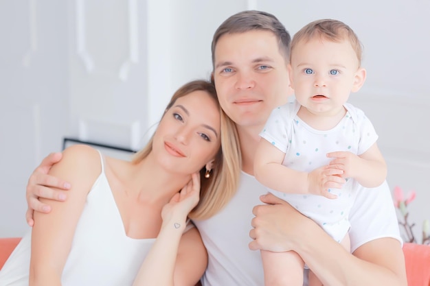 bebé con padres en una casa acogedora / familia joven y saludable mamá papá y bebé, sonrisa de felicidad