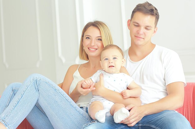 bebé con padres en una casa acogedora / familia joven y saludable mamá papá y bebé, sonrisa de felicidad