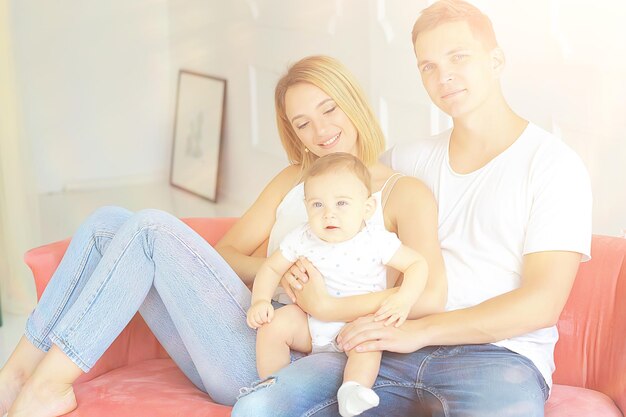 bebé con padres en una casa acogedora / familia joven y saludable mamá papá y bebé, sonrisa de felicidad