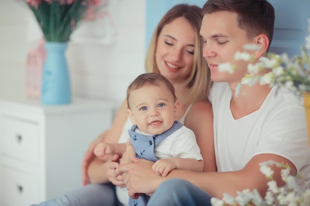 bebé con padres en una casa acogedora / familia joven y saludable mamá papá y bebé, sonrisa de felicidad