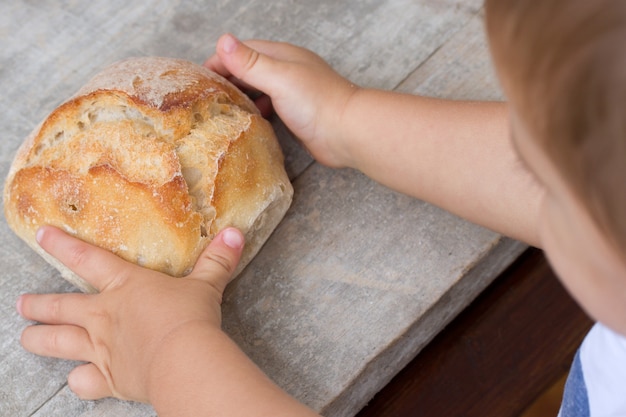 Bebé con pan fresco en la mano