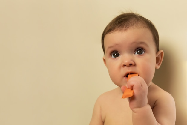 El bebé en el pañal está sentado en la mesa de la cocina.