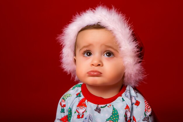 Bebê papai noel em fundo vermelho, espaço para texto