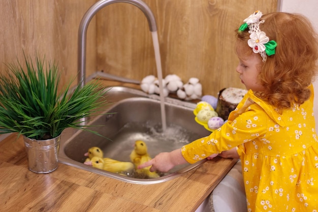 Un bebé para Pascua con patitos amarillos Junto al pastel y huevos pintados Vacaciones Familia Felicidad