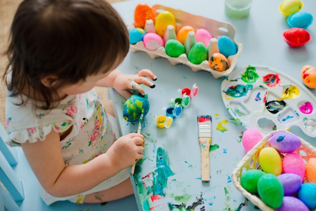 Bebé pintando huevos de pascua