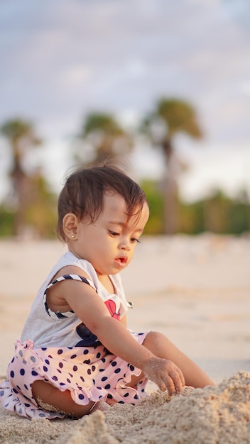 bebé en la playa disfrutando jugando en la arena