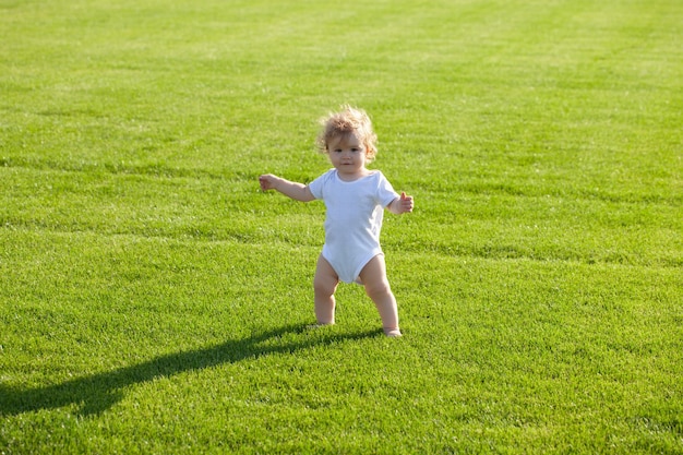 bebé, posición, descalzo, en, el, césped verde, niño sano