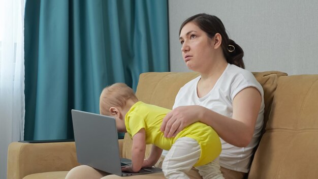 Bebê quer atenção da mãe e brinca com laptop