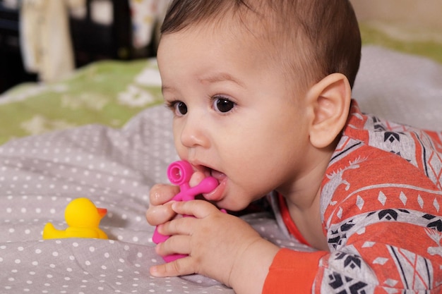 Foto bebê recém-nascido adorável brincando com brinquedo de cascavel colorido bebê com dente de seis meses de idade retrato de bebê adorável em branco com brinquedo de dente
