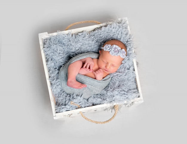 Foto bebé recém-nascido adormecido em caixa de madeira