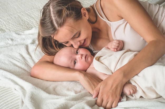 Bebê recém-nascido com a mãe na cama