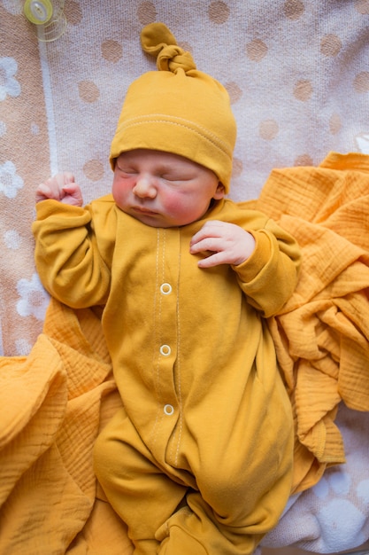 Foto bebê recém-nascido com roupas laranja. uma criança nascida no outono. recém-nascido no hospital