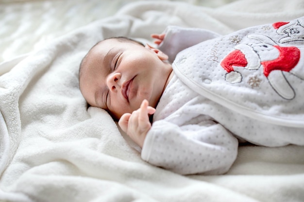 Bebê recém-nascido deitado coberto com cobertor branco
