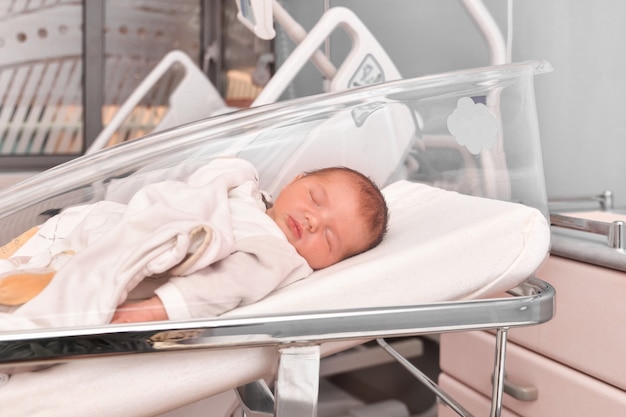 Bebê recém-nascido dormindo na cama do hospital