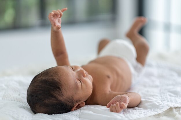 Bebê recém-nascido dormindo na cama