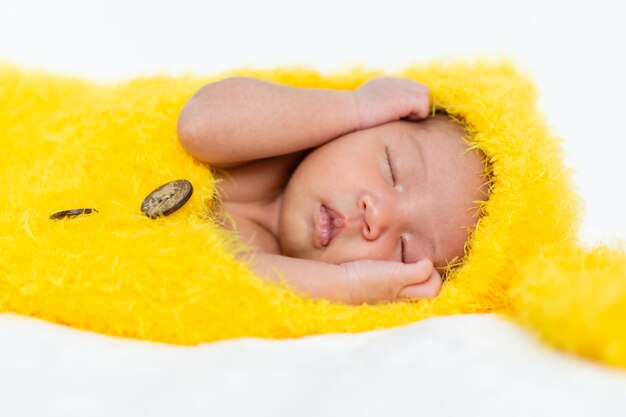 Bebê recém-nascido em terno de pele de coelho dormindo em uma cama