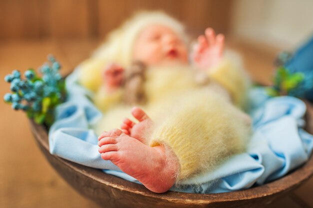 Foto bebê recém-nascido em um traje amarelo