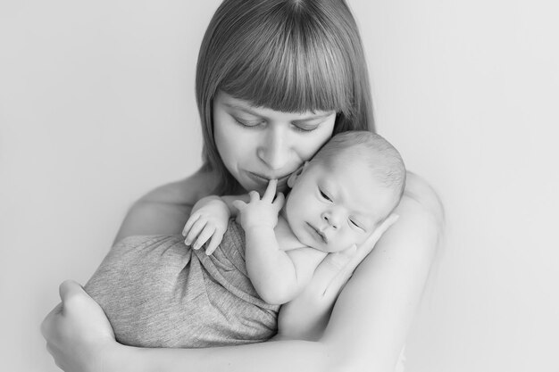 bebê recém-nascido nos braços da mãe, foto preto e branco, monocromática. cuidado parental para uma nova vida