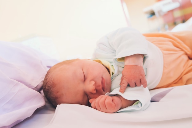 Bebê recém-nascido primeiros dias de vida na sala de parto. bebê dormindo no hospital após o parto