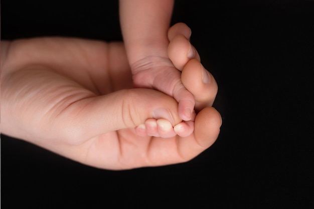 bebê recém-nascido segura o dedo da mãe. mão de um bebê recém-nascido