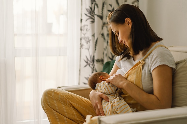 Bebé recém-nascido sugando leite do seio da mãe