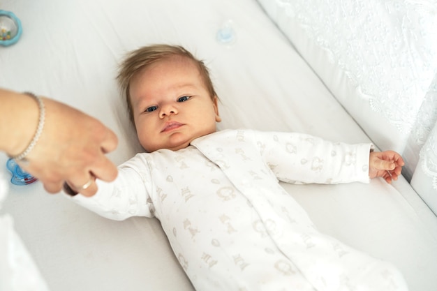 Foto un bebé recién nacido está acostado en la guardería en la cama.