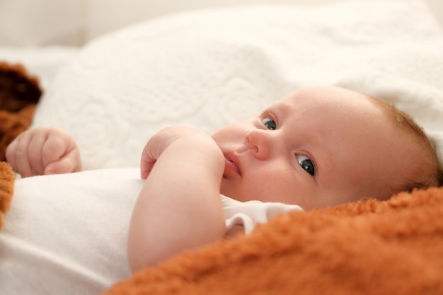 El bebé recién nacido se acuesta en la cama, el bebé juega en la cama.