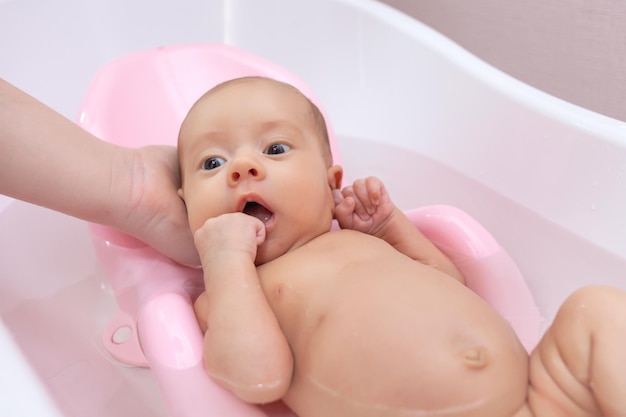 un bebé recién nacido bañado en la bañera, tobogán para nadar