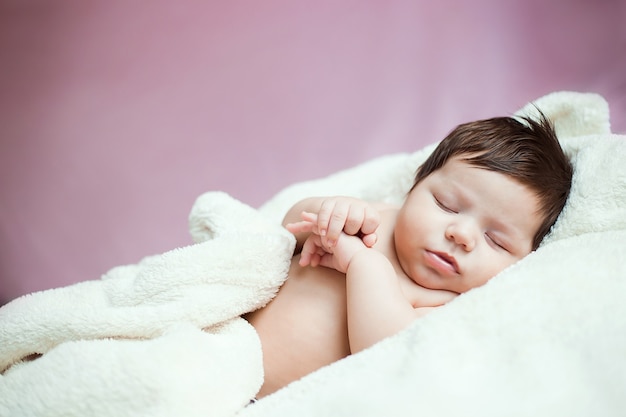 bebé recién nacido con cabello oscuro y grueso está durmiendo