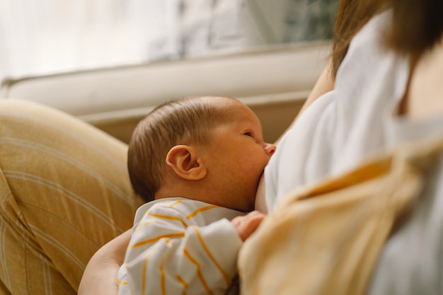 Bebé recién nacido chupando leche del pecho de la madre