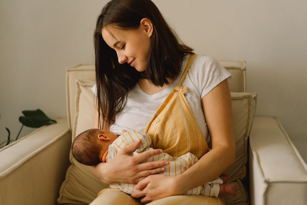 Bebé recién nacido chupando leche del pecho de las madres. Retrato de mamá y bebé lactante. Concepto de nutrición de lactancia materna sana y natural.