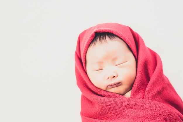 Foto bebé recién nacido en daiper rojo durmiendo en la cama